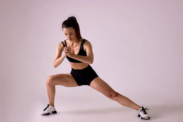 Saludable caucásico ajuste hembra en ropa de deporte haciendo saltos en estudio sobre rosa fondo —  Fotos de Stock