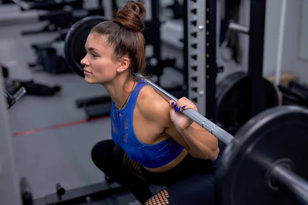 Fitness mulher treinamento com barra pesada para puxar, agachamento, fitness no ginásio. — Fotografia de Stock