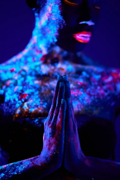 Schwarzes Gebet mit in der Dunkelheit leuchtender UV-Körperkunst, farbenfrohe Ethno-Prints auf nackter Haut — Stockfoto