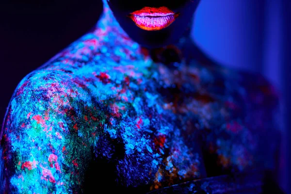 Nahaufnahme Porträt einer Frau mit dunkler Haut in fluoreszierender Körperkunst im Neonlicht — Stockfoto