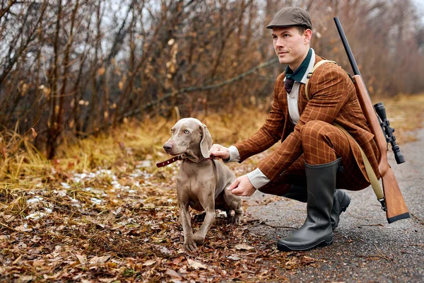 El chico sonriente con la raza de perros Weimaraner pasea por el bosque. Entrenamiento de perros de caza — Foto de Stock