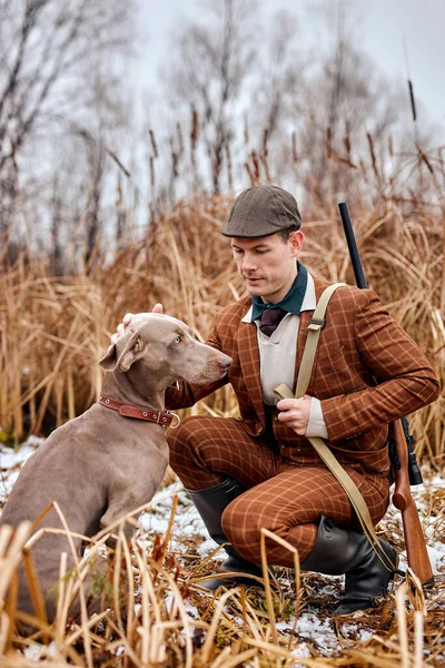 Genç adam avcısı köpekle birlikte sahada avlanmaya gidiyor, adam köpeği okşuyor. — Stok fotoğraf