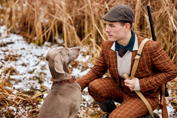 Caçador de chapéu com arma e weimaraner cão raça amigo na natureza. Incrível manhã de outono. — Fotografia de Stock