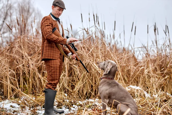 秋の狩猟シーズンを開きます。ポチャーオスハンターは命令を出し犬を訓練し — ストック写真