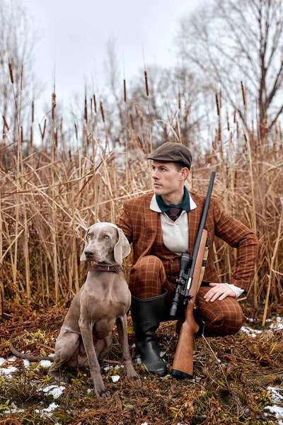 Självsäker amerikansk jägare man med hund håller hagelgevär promenader på landsbygden — Stockfoto