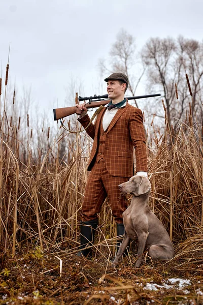 Cazador con perro de caza gris en bosque de otoño. Imagen tomada durante el viaje de caza mayor. —  Fotos de Stock