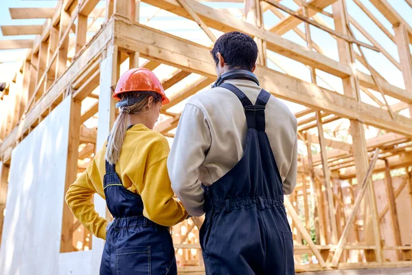 Blick von hinten auf zwei Bauarbeiter in Arbeitsuniform — Stockfoto