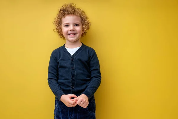 Dulce niño buscando vacío espacio sonriendo aislado en color amarillo fondo — Foto de Stock