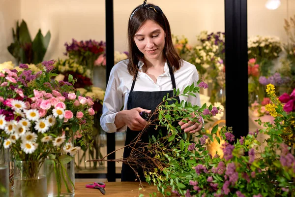 Foto de florista moderno exitoso que usa delantal haciendo ramo de flores — Foto de Stock