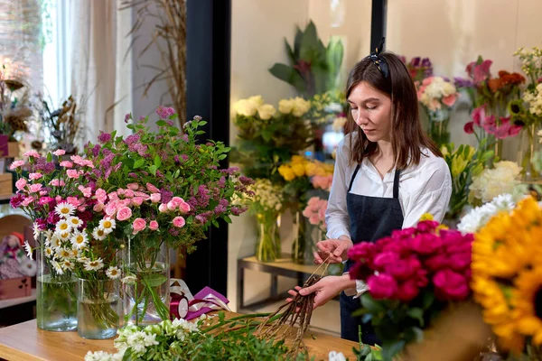 Florista profesional femenina prepara el arreglo de flores silvestres. Floristería — Foto de Stock