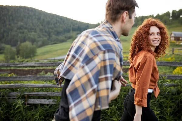 幸せなカップル田舎で夜に歩くと、赤毛の巻き女性は愛にあります — ストック写真