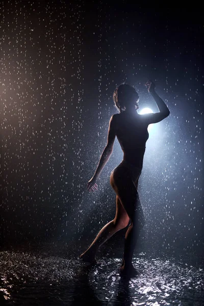 Приваблива сексуальна біла жінка у відвертій білизні позує під дощем, краплі води — стокове фото