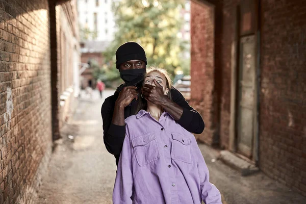 Αφρο-Αμερικανός κλέφτης οπλισμένος άντρας ληστεύει γυναίκα με όπλο στο δρόμο, γυναίκα είναι τόσο φοβισμένη, σοκαρισμένη φάτσα — Φωτογραφία Αρχείου
