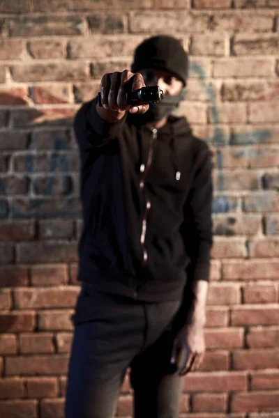 무장 한 남자 가 거리에서 총으로 사람들을 강탈, 위험 한 남자가 카메라를 향해 총을 겨누는 초상화 — 스톡 사진
