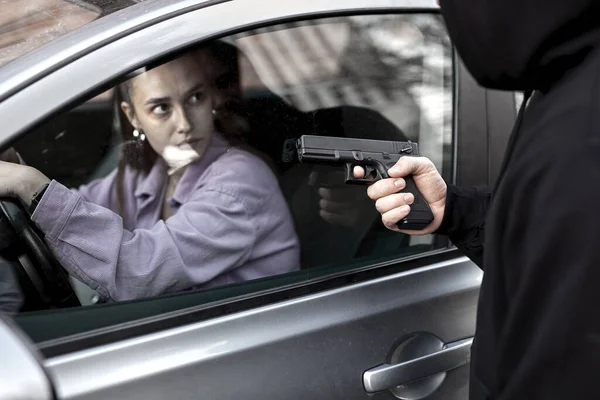 Bandido ladrón hombre sosteniendo arma de mano gángster para secuestrar rehén mujer conductor coche —  Fotos de Stock