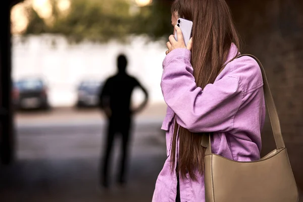 Brottslig stalking kvinna, begå ett brott medan offret gick ensam, prata i telefon — Stockfoto