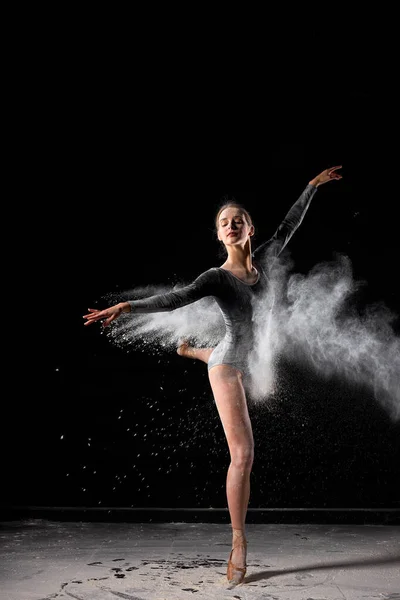 Krásná baletka žena v černém bodysuit krásně tančí balet v tmavém studiu — Stock fotografie