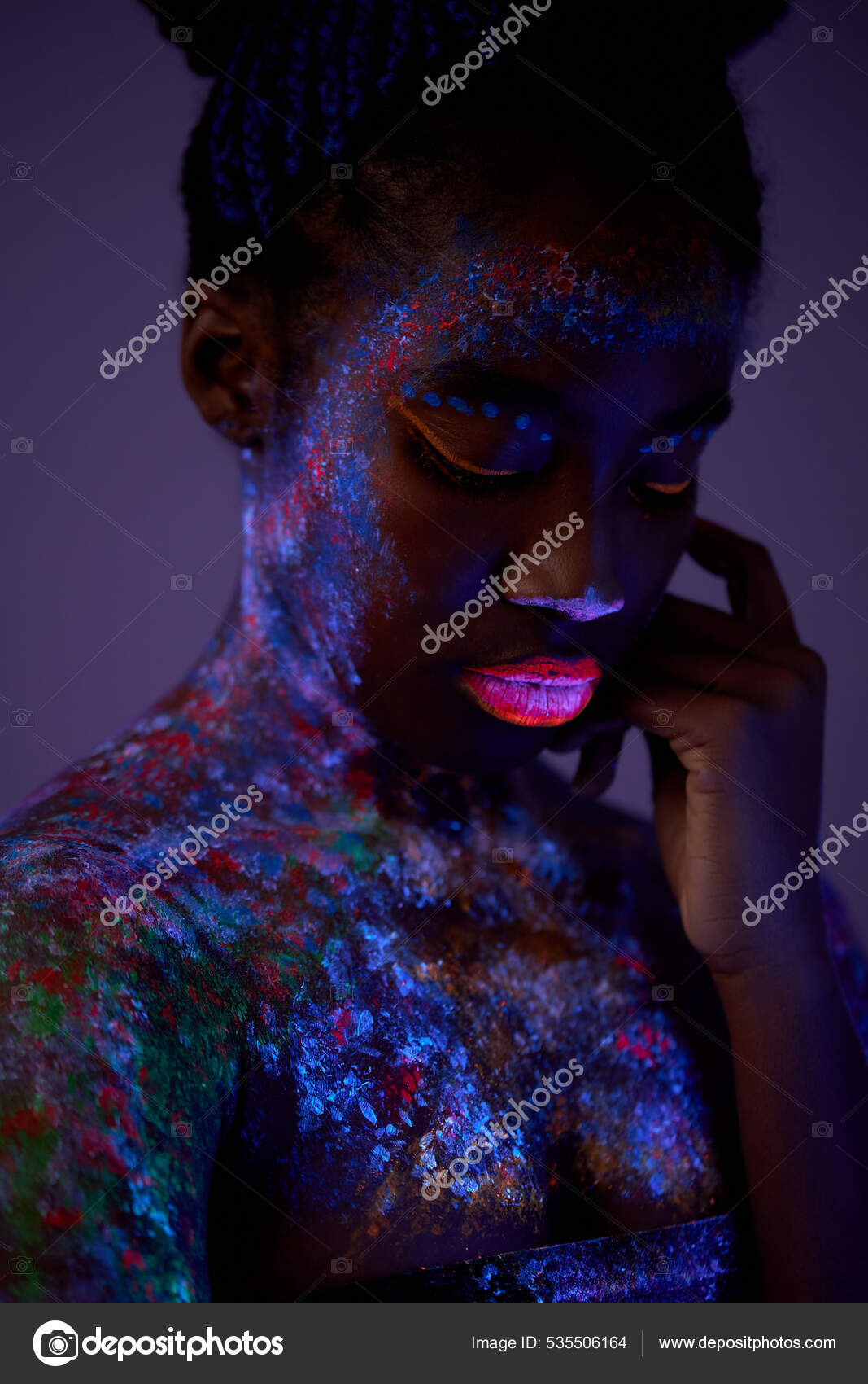 Sensual woman with black skin in fluorescent paint makeup, posing