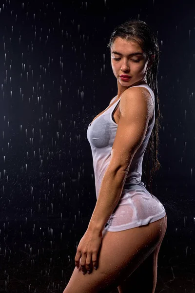 Schöne wohlgeformte athletische brünette Frau mit großen Brüsten und nassem Körper posiert vor der Kamera — Stockfoto