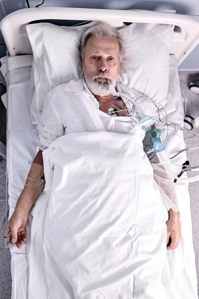 Vista dall'alto su uomo anziano malato ha trasfusione di sangue in ospedale, paziente con tubo in bocca — Foto Stock