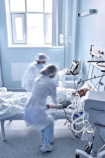 Oigenkännliga läkare sjuksköterskor rädda patienten man från döden liggande på sjukhus — Stockfoto