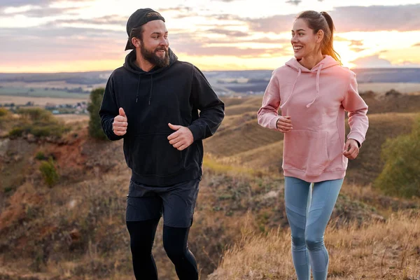 En primer lugar pareja corriendo corriendo al aire libre juntos, hablando, disfrutando del deporte fuera de la ciudad — Foto de Stock