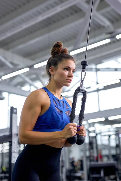 Mulher treinando com tríceps kickback no ginásio moderno. ajuste atleta senhora concentrada no treino — Fotografia de Stock