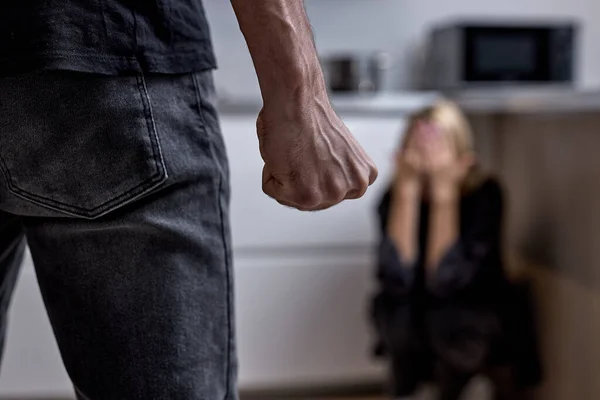 Marido alcohólico golpea a la esposa con el puño. La mujer se cubre con las manos. Violencia — Foto de Stock