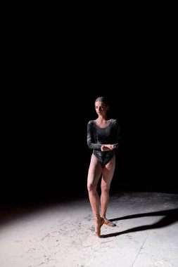 Güzel Bale Dansçısı Pointes 'e poz veriyor, tek başına dans etmeye hazırlanıyor, stüdyoda siyahların üzerinde.