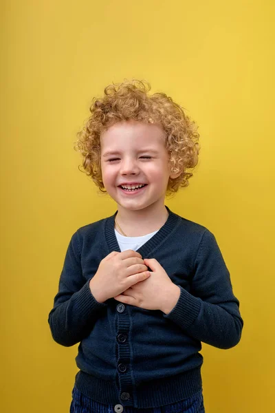 Niño emocionado sosteniendo las manos en el pecho cerca del corazón, agradecido, soñando. Emociones humanas — Foto de Stock