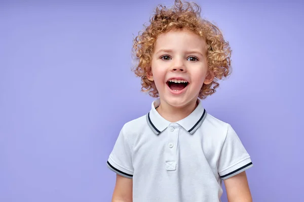 Glada liten unge med lockigt hår skrattar efter att ha hört roligt skämt från vän. — Stockfoto