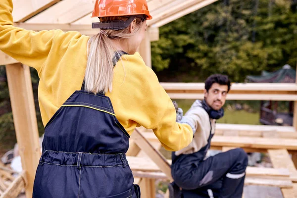 Vue de dos sur dame en uniforme de travail obtenir de l'aide de l'homme donnant instrument outil — Photo