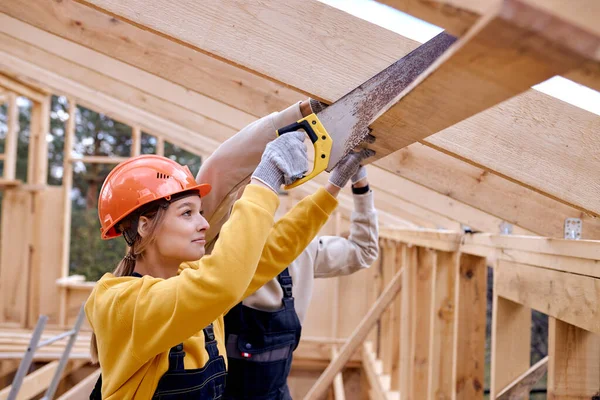 木造住宅敷地内で手切断木梁を使用して女性請負業者. — ストック写真
