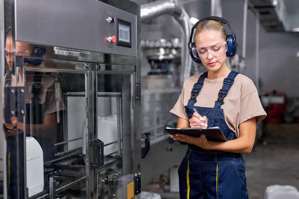 Female factory worker hold quality control at work, take notes into folder-tablet — Stock Photo, Image