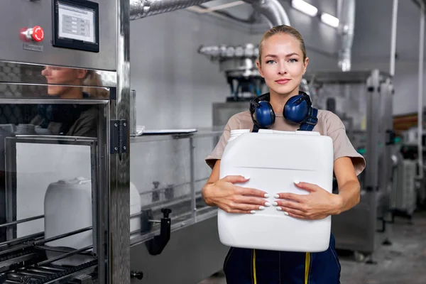 Confident enginner female holding plastic bottles canister in hands posing — Stock Photo, Image