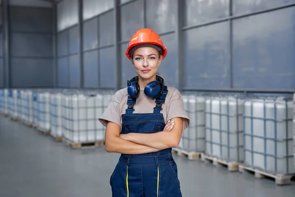 Industrial woman engineer in hardhat standing in factory with arms folded — Stock Photo, Image