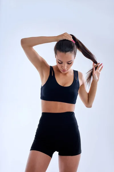 아름다운 코카서스 날씬 한 몸매의 여자가 포니테일을 하면서 운동 경기 준비를 하고 있다 — 스톡 사진