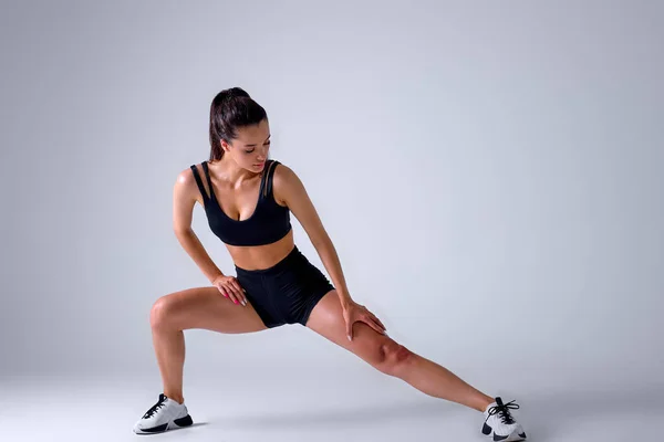 Caucásico Mujer de fitness haciendo ejercicios de embestidas para el entrenamiento muscular de la pierna, aislado — Foto de Stock