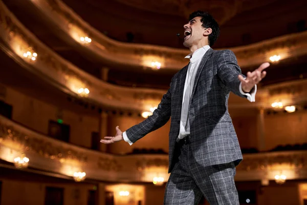 professional opera singer in elegant classic outfit, singing hit with open mouth