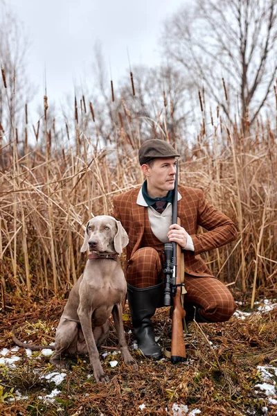 Uppmärksam Man med hund sitter i buskar och jagar ett djur, i vild natur — Stockfoto