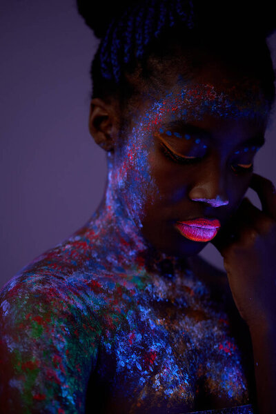 black woman with colorful abstract make-up on face. unusual, fantastic shoot