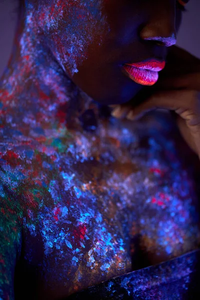 Beskärd sensuell kvinna med svart hud i fluorescerande färg makeup, poserar framför kameran — Stockfoto