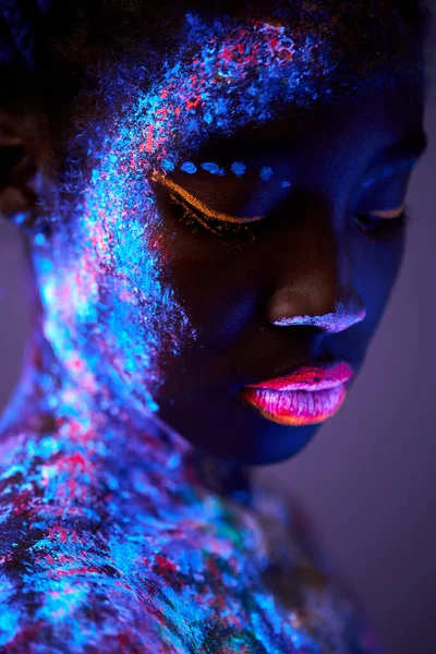 Fekete nő testművészeti világítással az ultraibolya fényben. Egy gyönyörű nő portréja — Stock Fotó