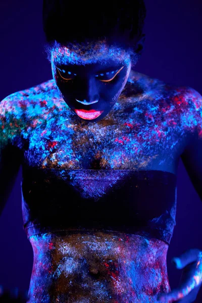 Feminino preto fascinante esbelto com arte do corpo do néon com pó fluorescente posando — Fotografia de Stock
