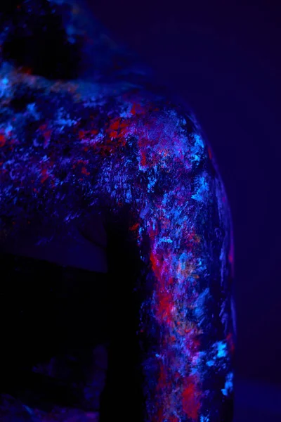 Close-up foto van zwarte vrouwelijke huid met fluorescerende schilderijen, body art, neon licht — Stockfoto