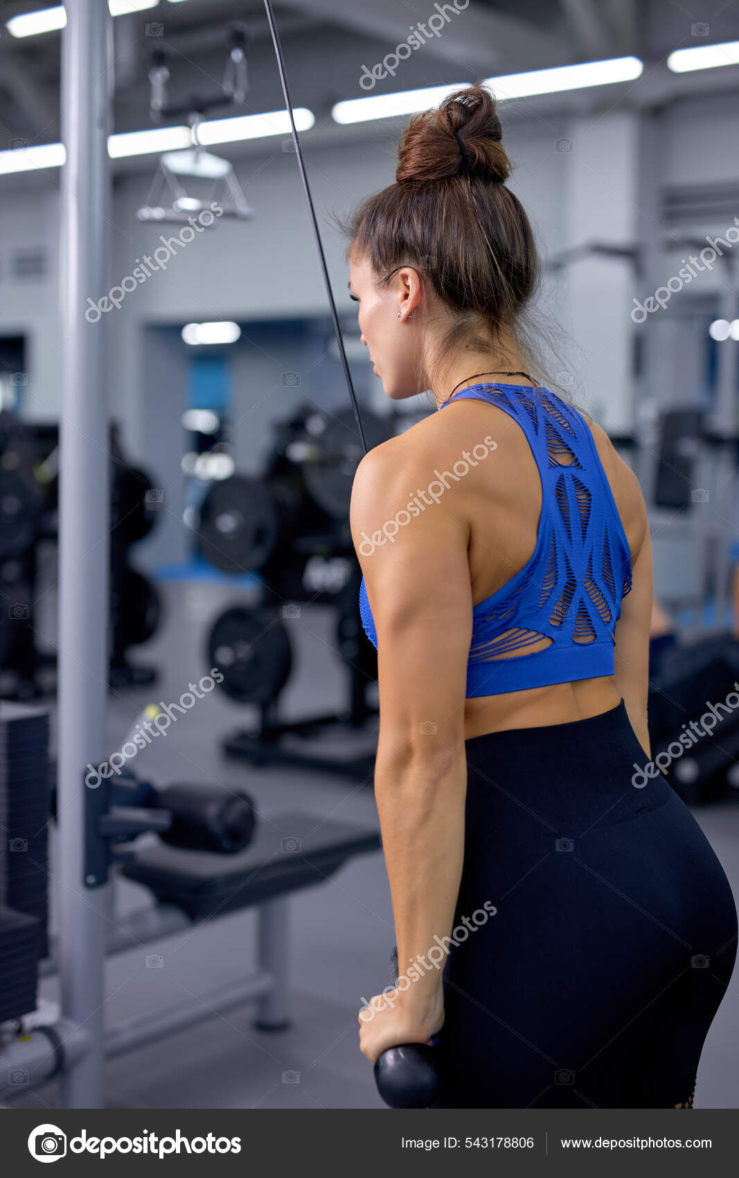 Woman training with triceps kickback in gym. fit athlete lady concentrated  on workout Stock Photo by ©ufabizphoto 543178806