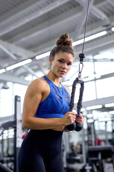 Sterke jonge vrouw presteren schouder pers met cross fitness apparatuur — Stockfoto