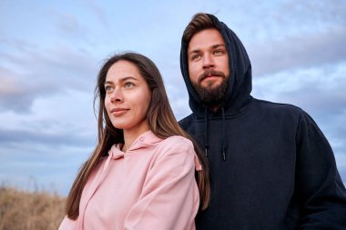 Erkek ve kadın harika bir manzarada koşuya hazırlanıyor, yana bakıyor.