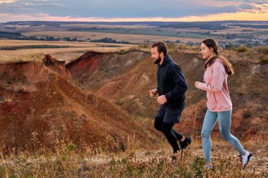 Dağlarda koşan, spor giysiler giyen, temiz havada koşan çiftler.