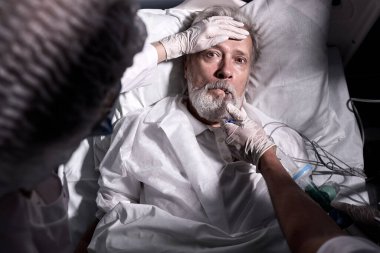 Hasta kıdemli adam yoğun bakımda, şok ve korku içinde uyandı. En üstteki görünüm, işlemden sonra